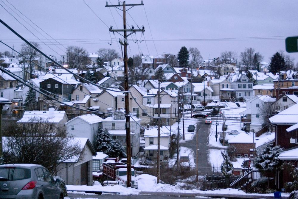 neighborhood on hill in snow at dusk