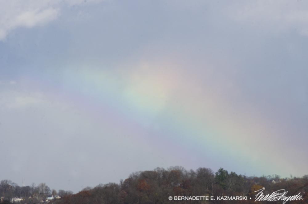 A rainbow spreading across the sky.