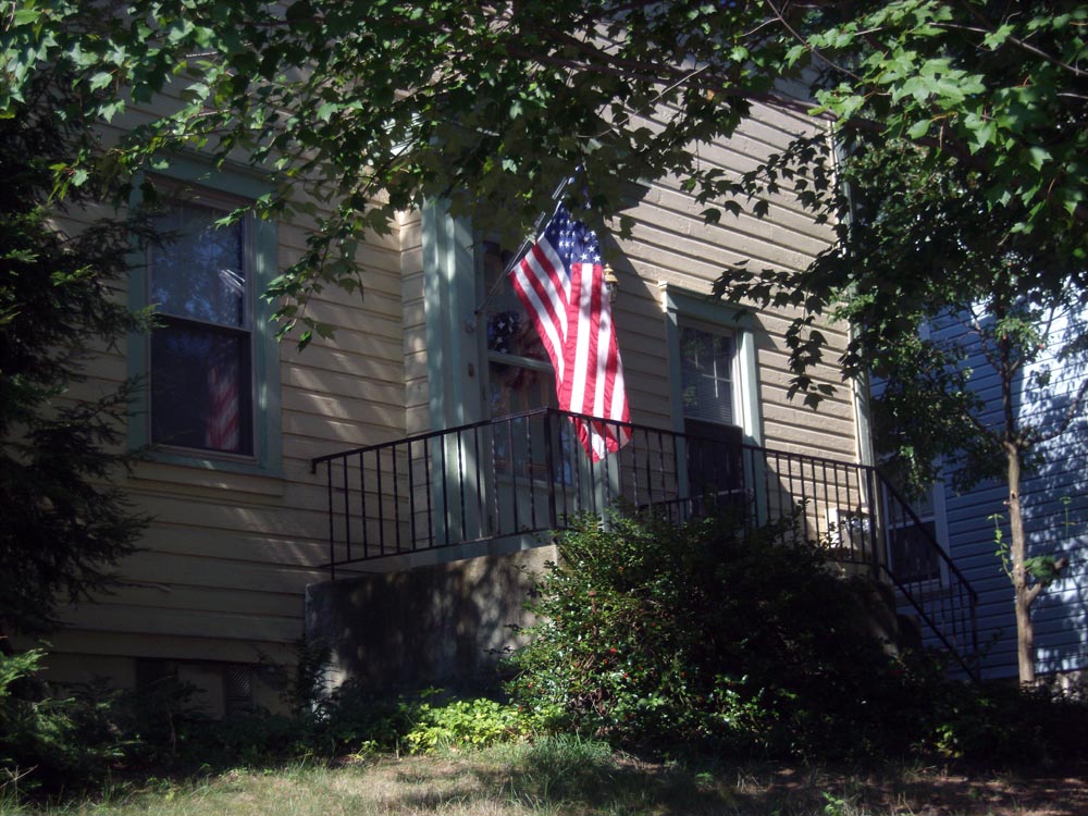 photo of porch with flag under tree