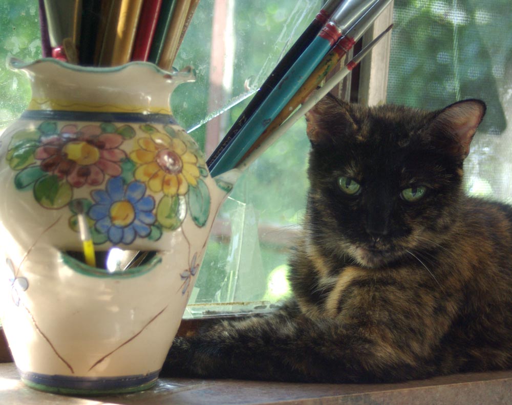 tortoiseshell cat with paintbrushes