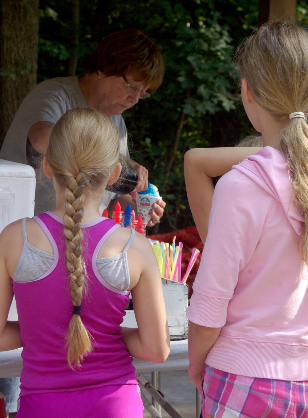 two girls in pink wait for their snowcone