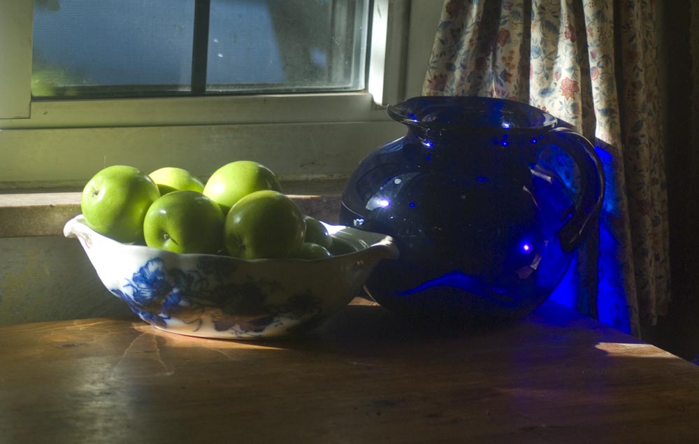 still life of green apples and blue pitcher