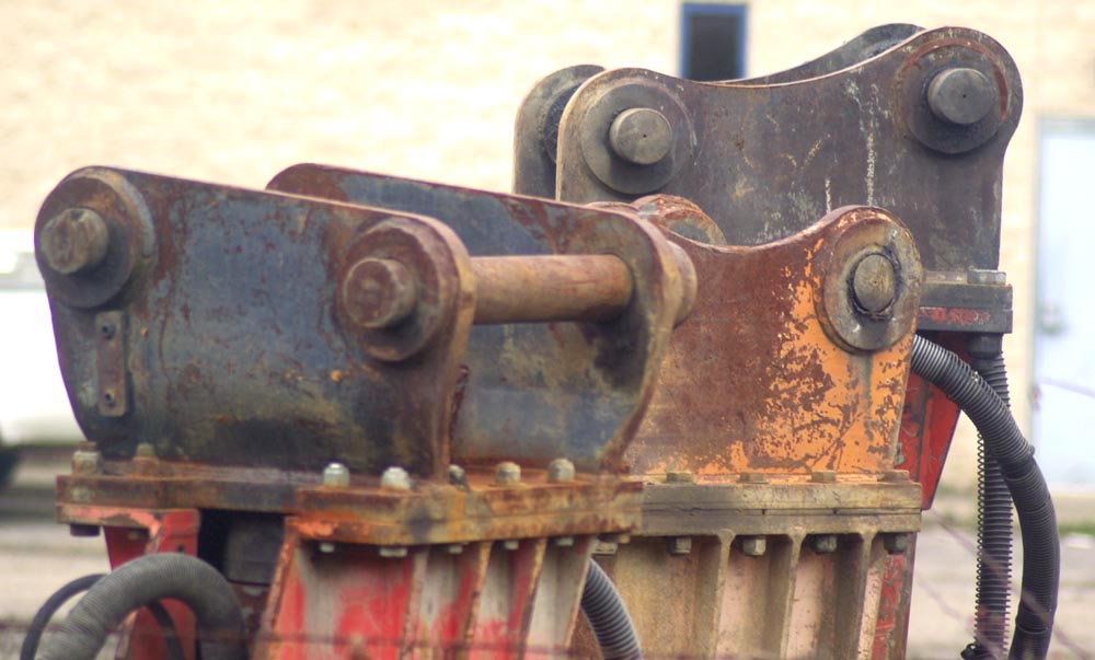 three rusted industrial parts