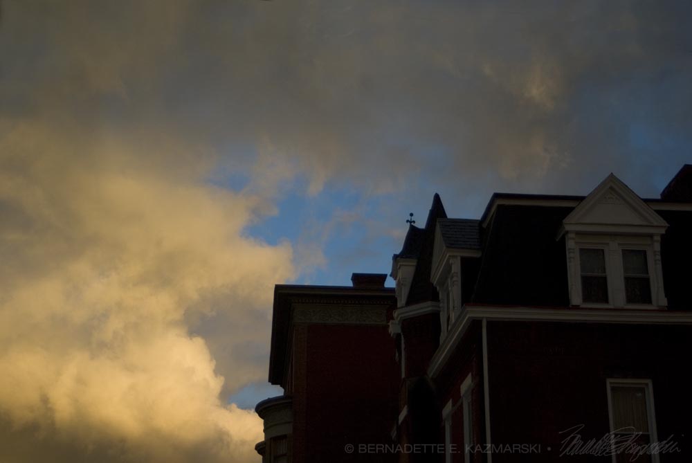 storm clouds over a victorian house